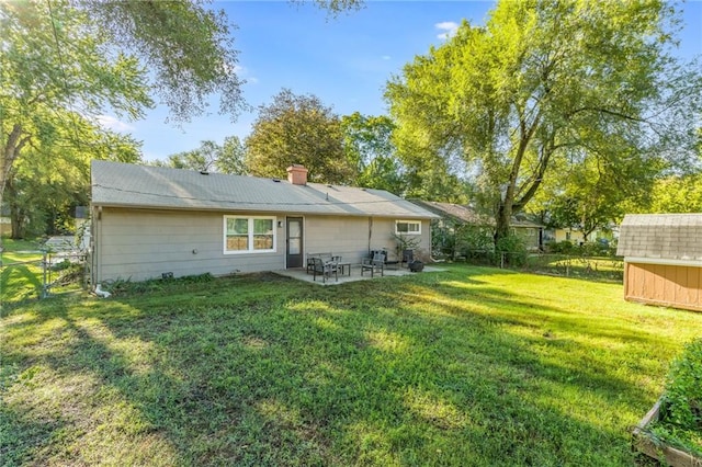 back of property featuring a storage unit, a patio, and a yard