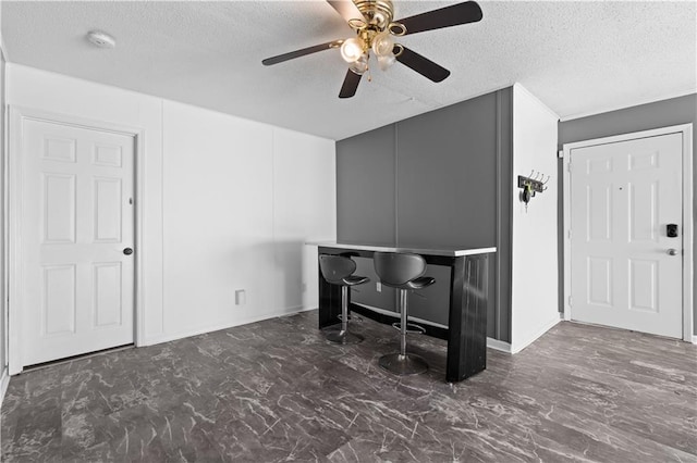 interior space featuring ceiling fan and a textured ceiling