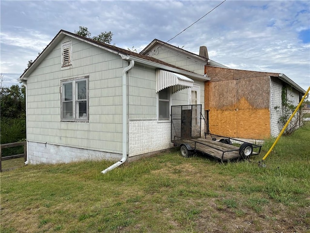 rear view of house featuring a lawn