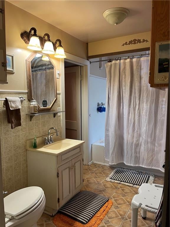 full bathroom with vanity, tile walls, shower / tub combo, and toilet