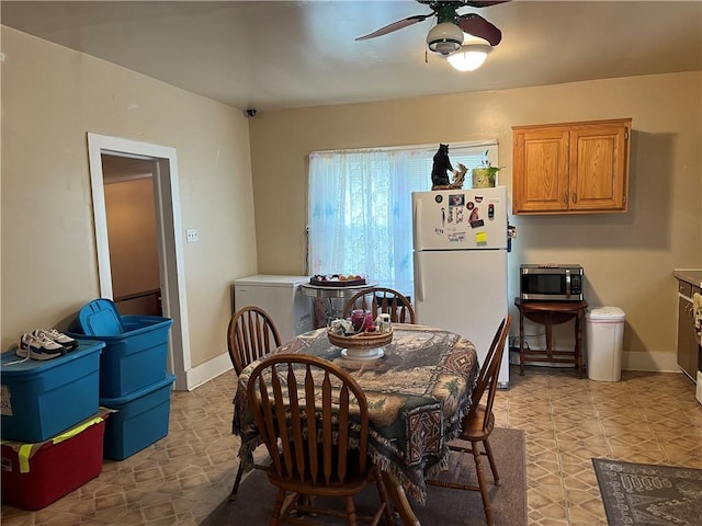 dining room with washer / clothes dryer, ceiling fan, and light tile patterned floors