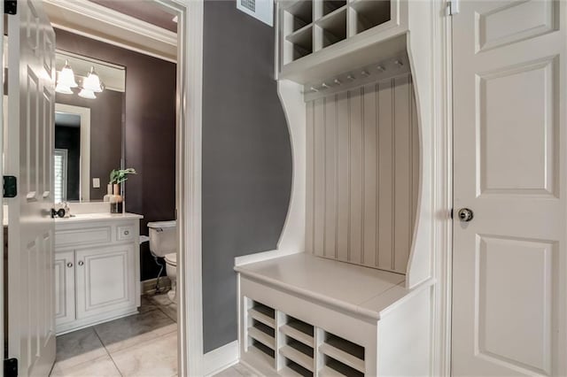 mudroom featuring an inviting chandelier and light tile patterned floors