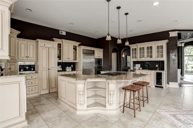 kitchen featuring cream cabinetry, wine cooler, an island with sink, built in appliances, and ornamental molding