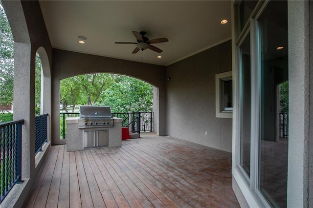 wooden deck with grilling area, area for grilling, and ceiling fan