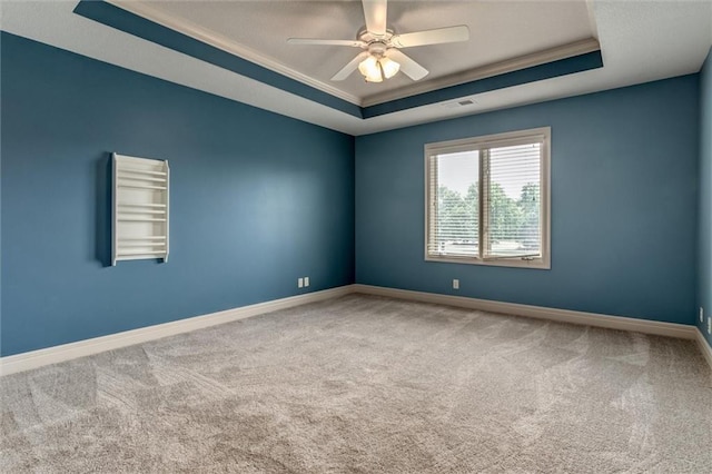 spare room featuring carpet, ceiling fan, a raised ceiling, and crown molding