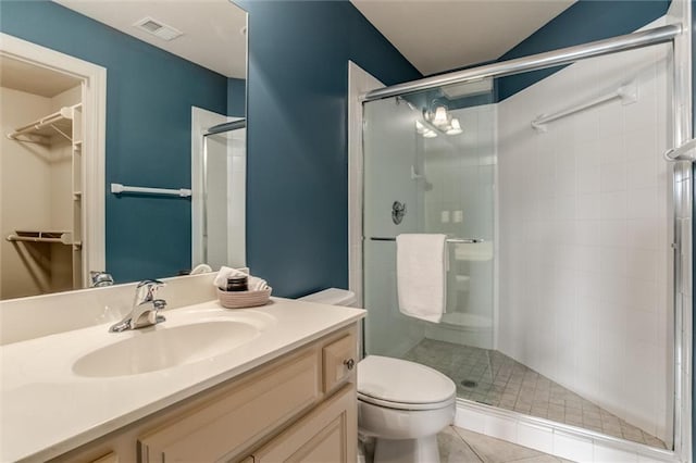 bathroom with vanity, toilet, an enclosed shower, and tile patterned floors