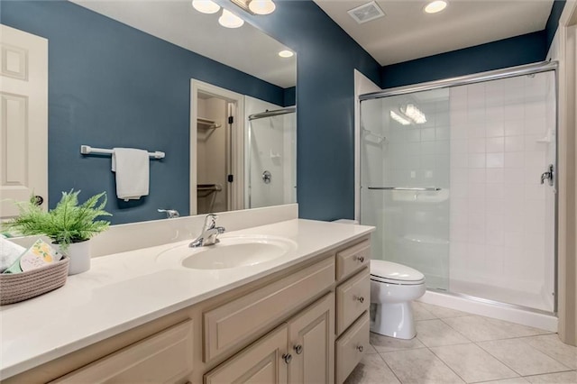 bathroom with walk in shower, vanity, toilet, and tile patterned floors