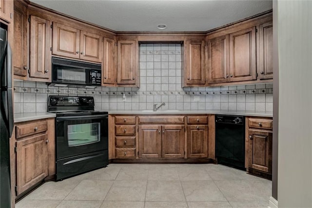 kitchen featuring black appliances, decorative backsplash, light tile patterned floors, and sink