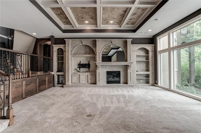 unfurnished living room with beamed ceiling, coffered ceiling, carpet floors, and a fireplace