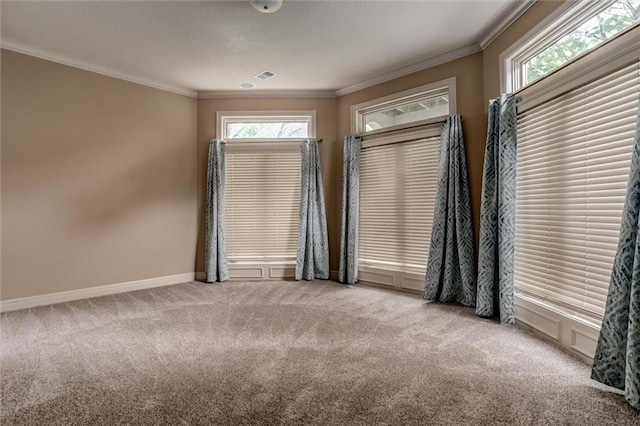 carpeted spare room featuring ornamental molding and a wealth of natural light