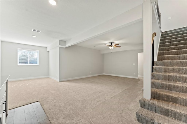 unfurnished living room featuring light colored carpet, visible vents, baseboards, and stairs