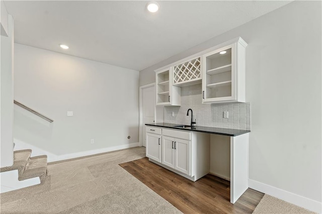 bar with baseboards, decorative backsplash, a sink, and recessed lighting