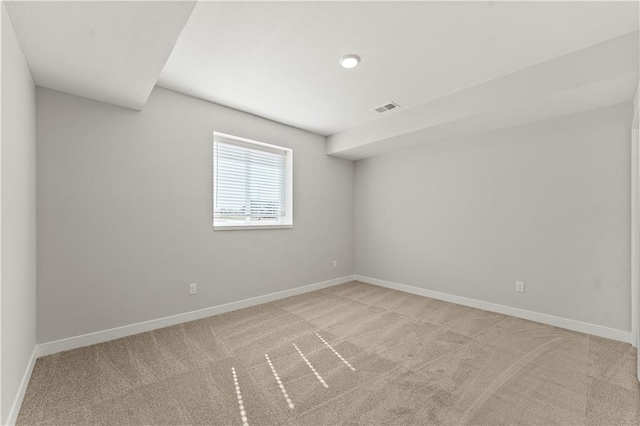 empty room featuring light carpet, visible vents, and baseboards