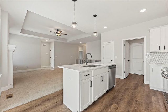 kitchen featuring visible vents, a raised ceiling, backsplash, a sink, and stainless steel dishwasher