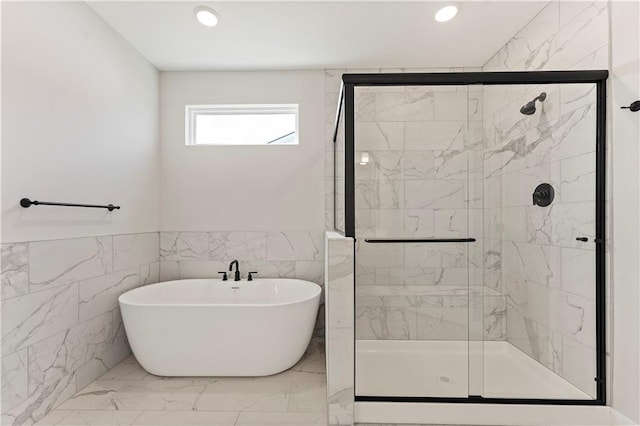 bathroom featuring recessed lighting, a freestanding bath, marble finish floor, wainscoting, and a stall shower