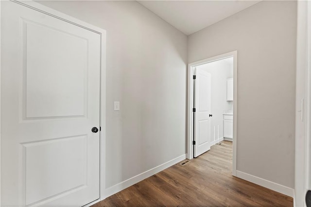 hallway with baseboards and wood finished floors