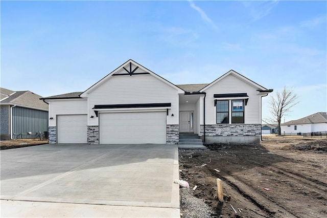 view of front facade with a garage, driveway, and stone siding