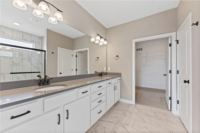 full bath with double vanity, a marble finish shower, visible vents, marble finish floor, and a sink