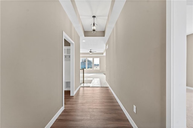 corridor with dark wood-style floors and baseboards