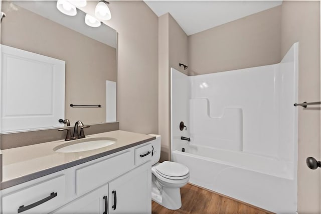 full bath featuring vanity, shower / bathing tub combination, wood finished floors, and toilet