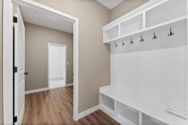 mudroom with dark wood finished floors and baseboards