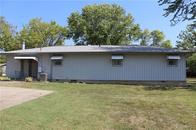 back of house featuring a lawn and cooling unit