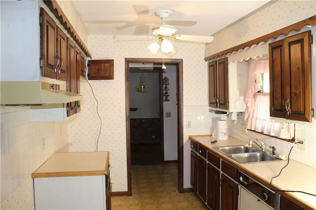 kitchen with tile walls, white dishwasher, dark brown cabinets, ceiling fan, and sink