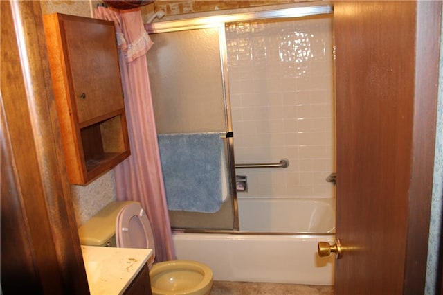 full bathroom featuring enclosed tub / shower combo, vanity, and toilet