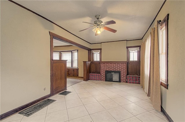 unfurnished living room with a brick fireplace, visible vents, and ornamental molding