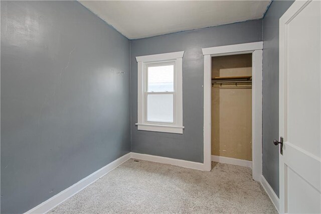 unfurnished bedroom featuring baseboards, a closet, and carpet flooring