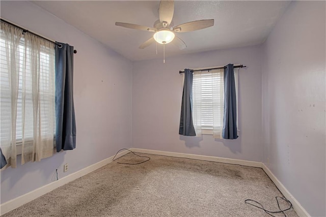 unfurnished room featuring carpet, a ceiling fan, and baseboards