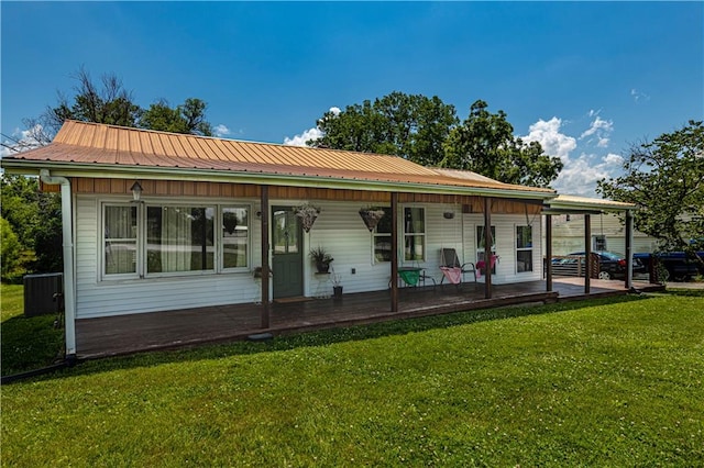 back of house with cooling unit, covered porch, and a yard