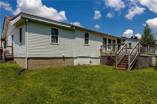 rear view of house with a yard and a wooden deck