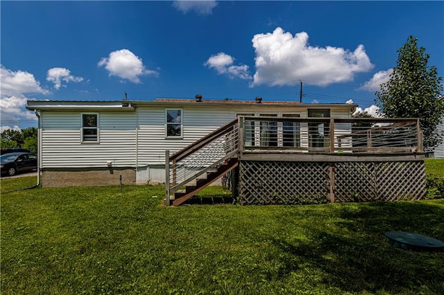 rear view of house featuring a yard and a wooden deck