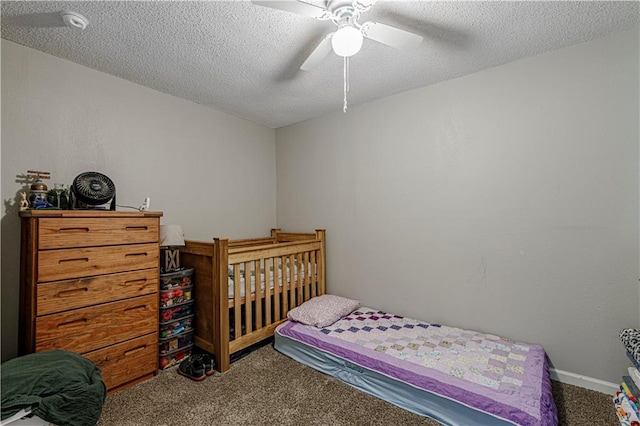 carpeted bedroom featuring ceiling fan and a textured ceiling