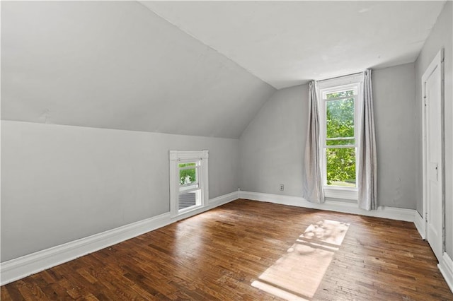 bonus room with dark wood-type flooring and lofted ceiling