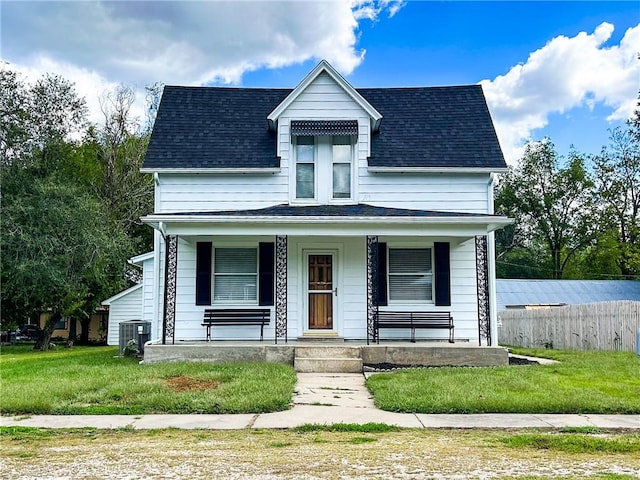 view of front of home with a porch, central air condition unit, and a front yard