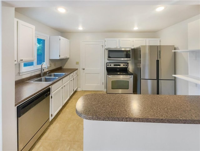 kitchen featuring white cabinetry, sink, light tile patterned floors, and stainless steel appliances