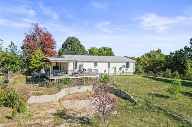 rear view of property with a lawn and a wooden deck