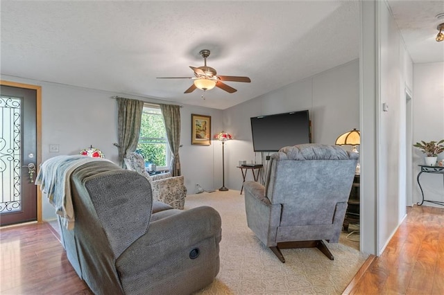 living room featuring light hardwood / wood-style floors, ceiling fan, and lofted ceiling