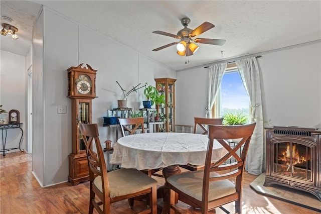 dining room featuring ceiling fan, wood-type flooring, and a textured ceiling