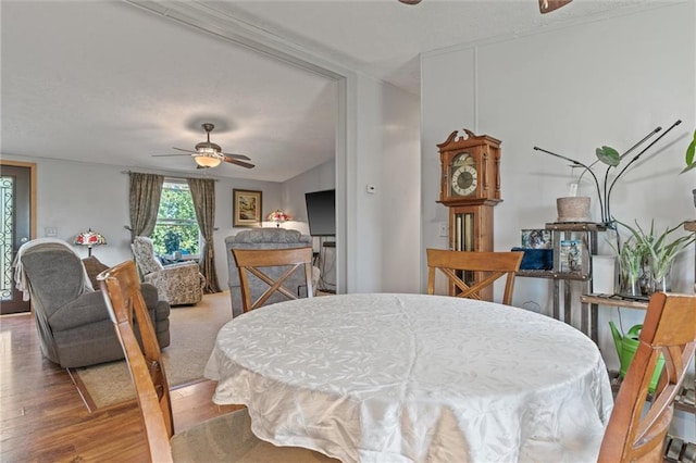 dining area with ceiling fan, wood-type flooring, and lofted ceiling