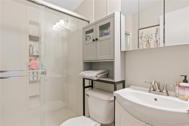 bathroom with a sink, a shower stall, and toilet