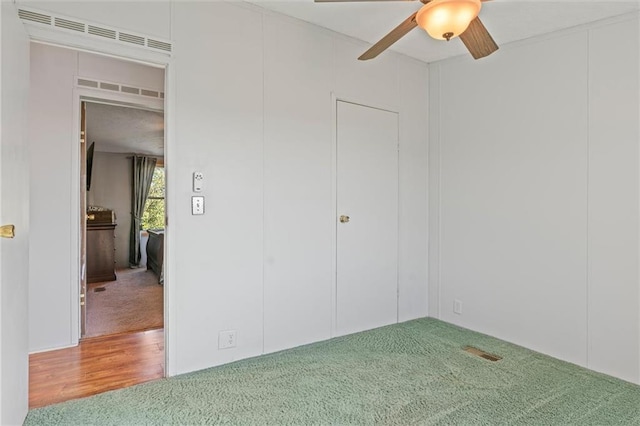 unfurnished bedroom featuring carpet floors, visible vents, and a ceiling fan