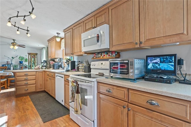 kitchen featuring ceiling fan, kitchen peninsula, a textured ceiling, white appliances, and light wood-type flooring