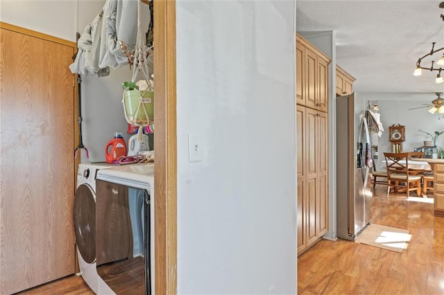 laundry area with cabinets, a textured ceiling, ceiling fan, independent washer and dryer, and light hardwood / wood-style floors