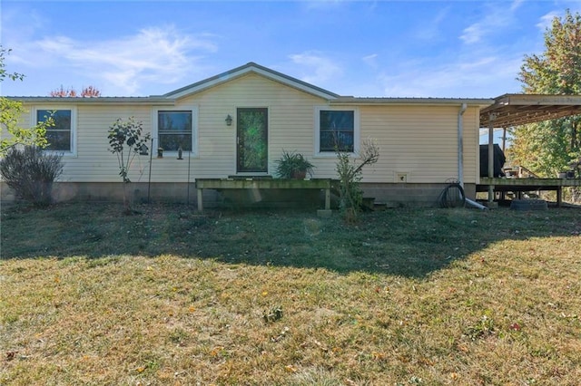 manufactured / mobile home featuring a carport and a front lawn