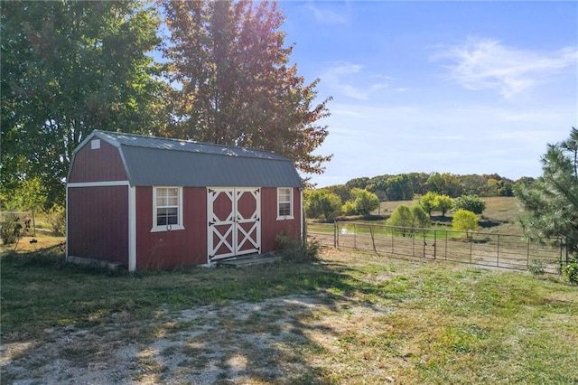 view of shed with a rural view and fence