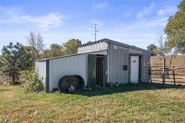 view of pole building with a lawn and fence