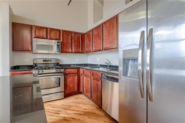 kitchen featuring sink, light wood-type flooring, and appliances with stainless steel finishes